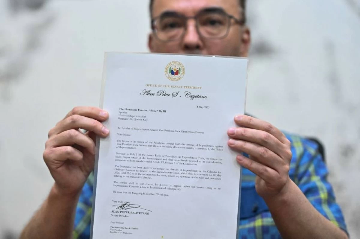 Philippine Senate President Alan Peter Cayetano shows the signed confirmation letter of the Articles of Impeachment against Vice President Sara Duterte at the Philippine Senate, in Pasay City, Metro Manila, Philippines, May 14, 2026. REUTERS/Noel Celis