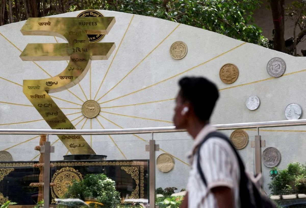 File picture: A man walks past an installation of the Rupee logo and Indian currency coins outside the Reserve Bank of India (RBI) headquarters in Mumbai, India. REUTERS