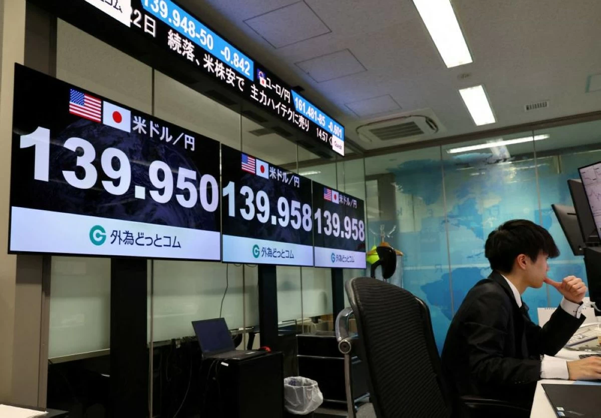 An employee of the foreign exchange trading company Gaitame.com works in front of monitors displaying the current Japanese Yen exchange rate against the U.S. dollar, at their dealing room in Tokyo, Japan, April 22, 2025. REUTERS/Kim Kyung-Hoo