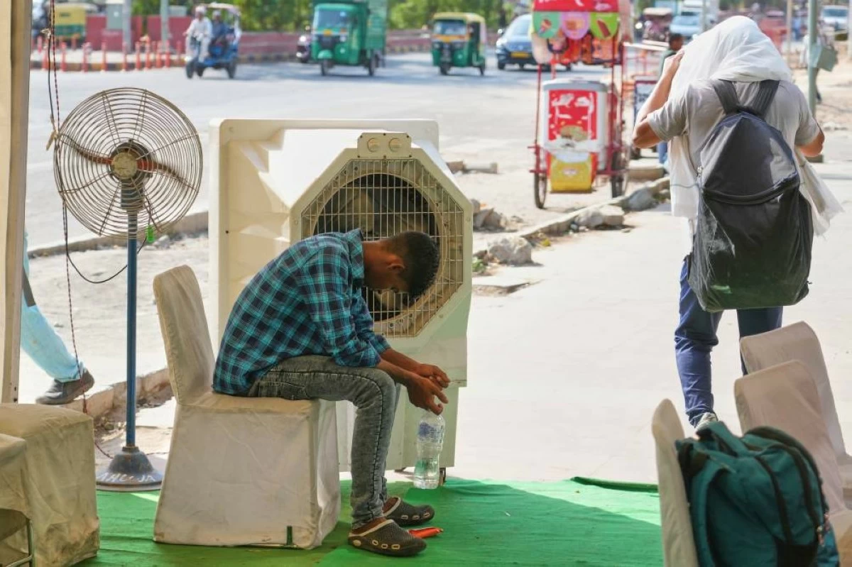 A man sits in front of a water cooler at a roadside cooling station set up by the government to provide relief for people from the intense summer heat in New Delhi, India, Wednesday, May 20, 2026. (AP Photo/Manish Swarup)