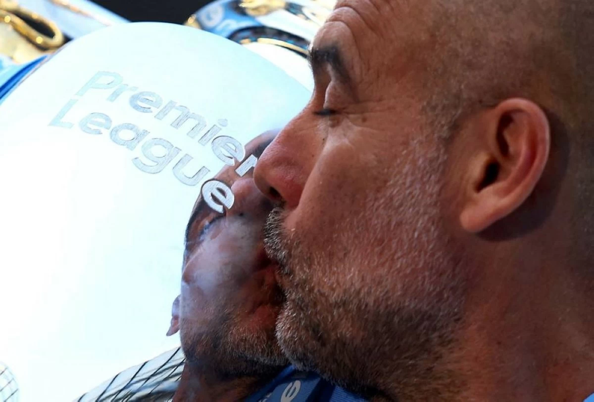 Manchester City manager Pep Guardiola kisses the trophy after winning the Premier League at Etihad Stadium, Manchester, Britain - May 19, 2024. (Reuters)