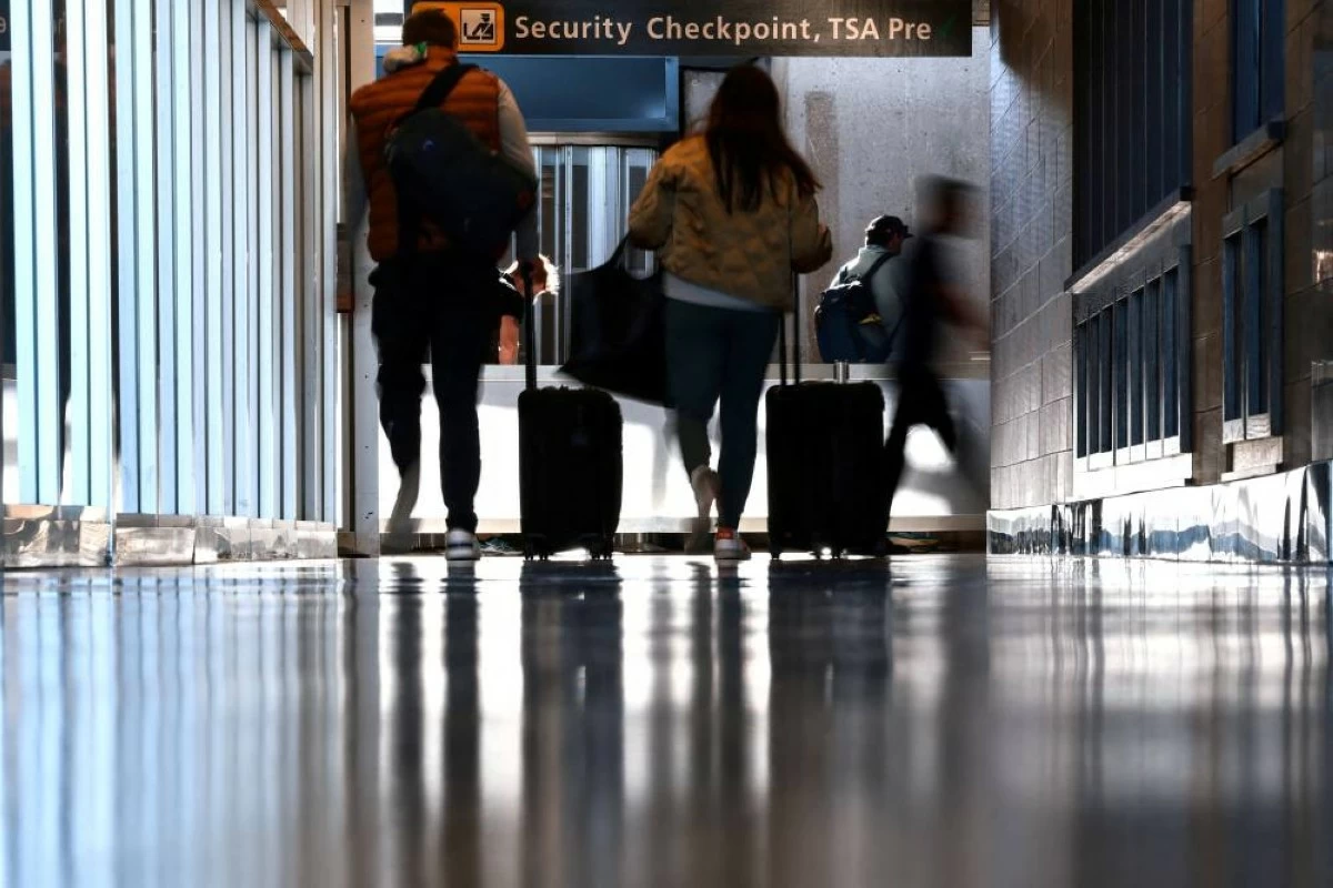 Travellers wait to pass a security checkpoint at Dulles International airport as the nation's air travel system begins to return to normal, as the U.S. government opens back up following the longest shutdown in U.S. history, in Dulles, Virginia, U.S. November 13, 2025. REUTERS/Evelyn Hockstein