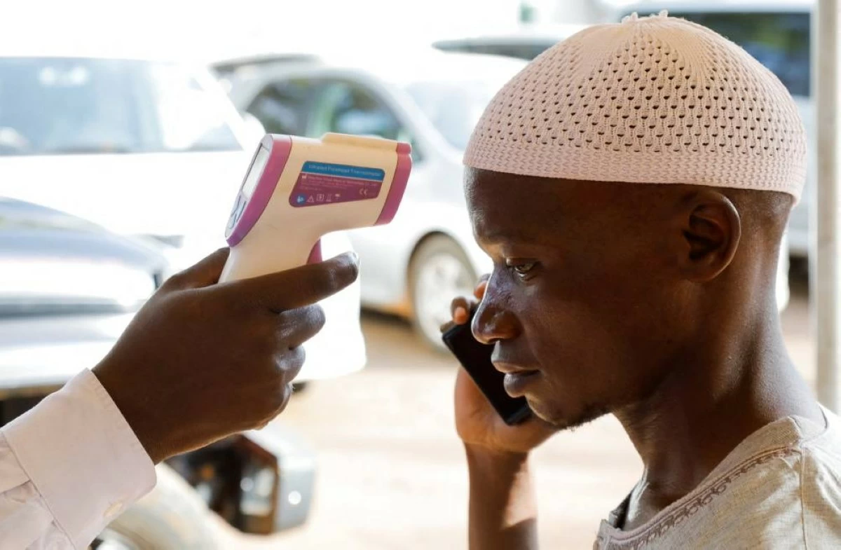 A medical officer checks the temperature of a man to screen against the spread of Ebola virus, as aid agencies intensify efforts to contain a new Ebola outbreak involving the Bundibugyo virus at the Platinum Medical Centre in Kampala, Uganda, May 26, 2026. REUTERS