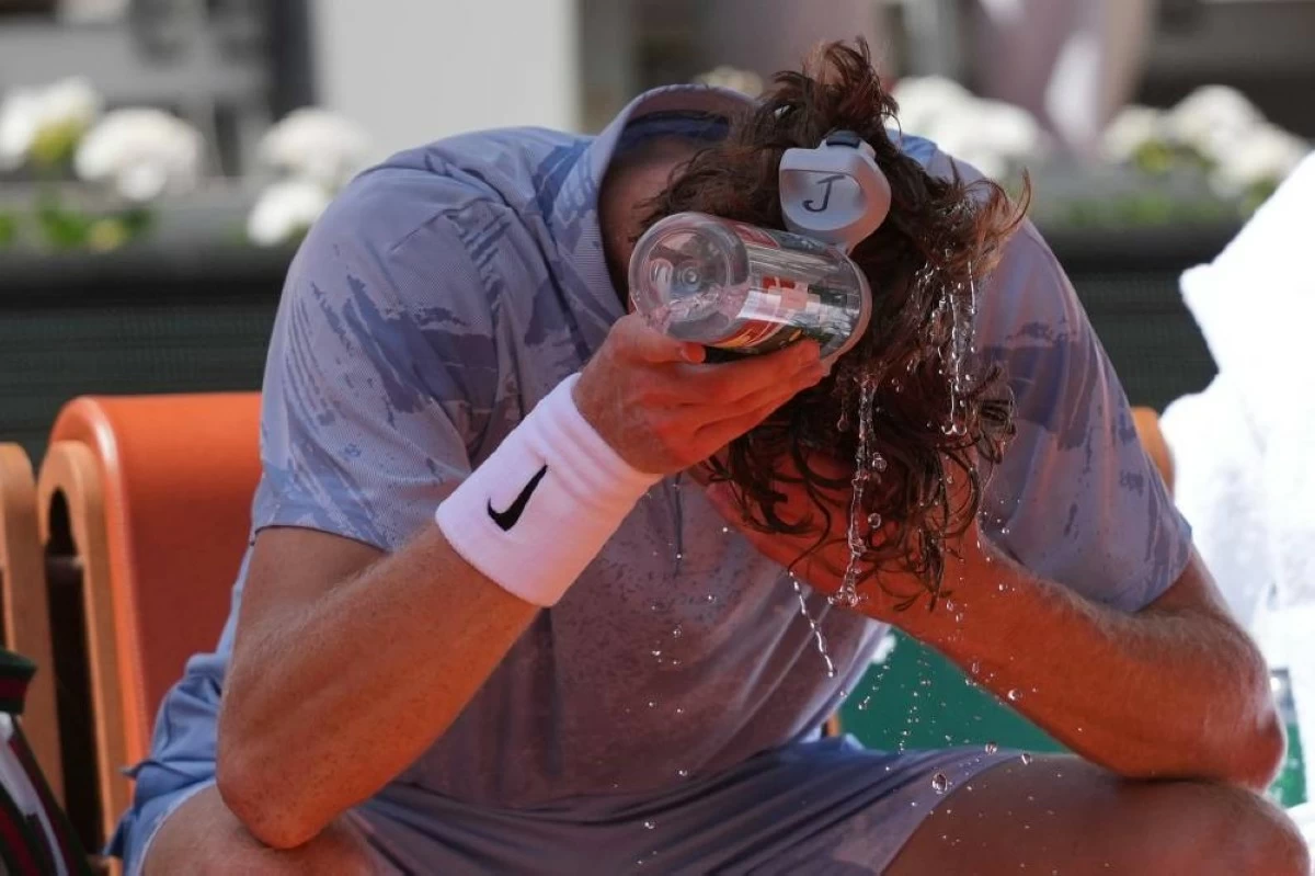 Jannik Sinner of Italy cools himself with the water during a break at the second round men's singles tennis match against Juan Manuel Cerundolo of Argentina at the French Open tennis tournament in Paris, Thursday, May 28, 2026. (AP Photo/Thibault Camus)
