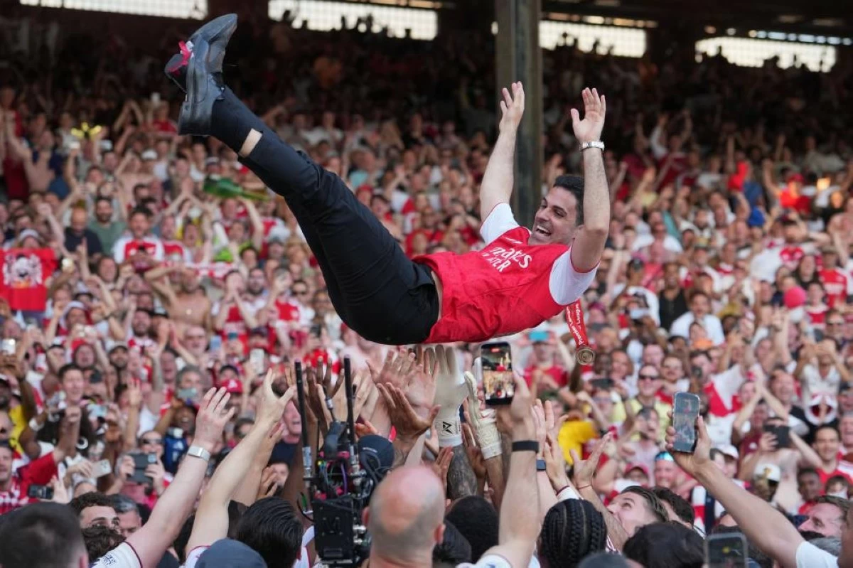 Arsenal's manager Mikel Arteta is thrown in the air by the players celebrating their Premier League title after the English Premier League soccer match between Crystal Palace and Arsenal in London, England, Sunday, May 24, 2026. (AP Photo/Kin Cheung)