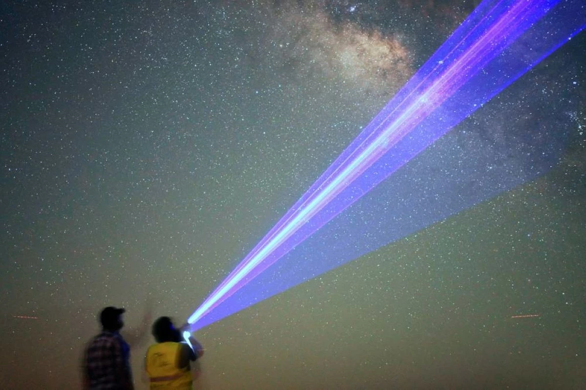 This long-exposure photograph shows men using a laser pointer to name the stars in the Milky Way galaxy in the Al Quaa Desert outside of Abu Dhabi, United Arab Emirates, Sunday, May 24, 2026. (AP Photo/Jon Gambrell)