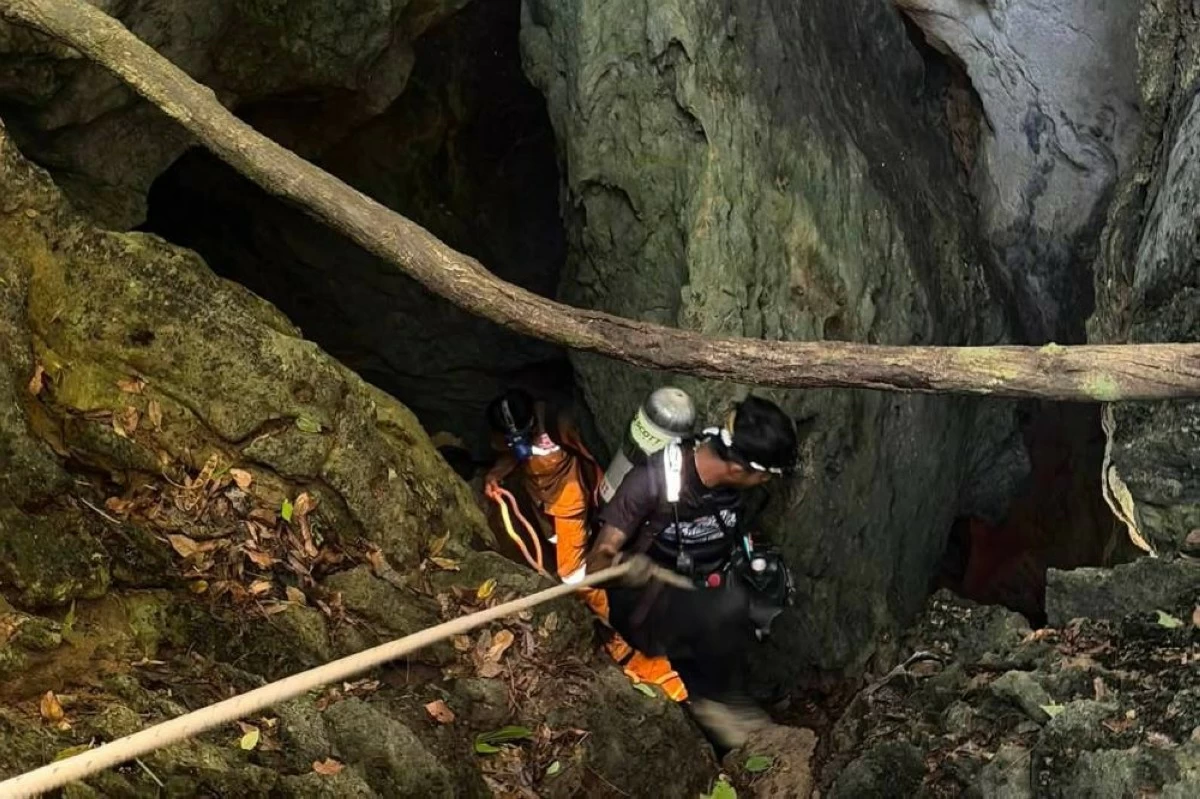 In this image released by Metta Tham Rescue Kalasin, rescuers try to reach people who have been trapped in a cave in Xaisomboun province, Laos. AP