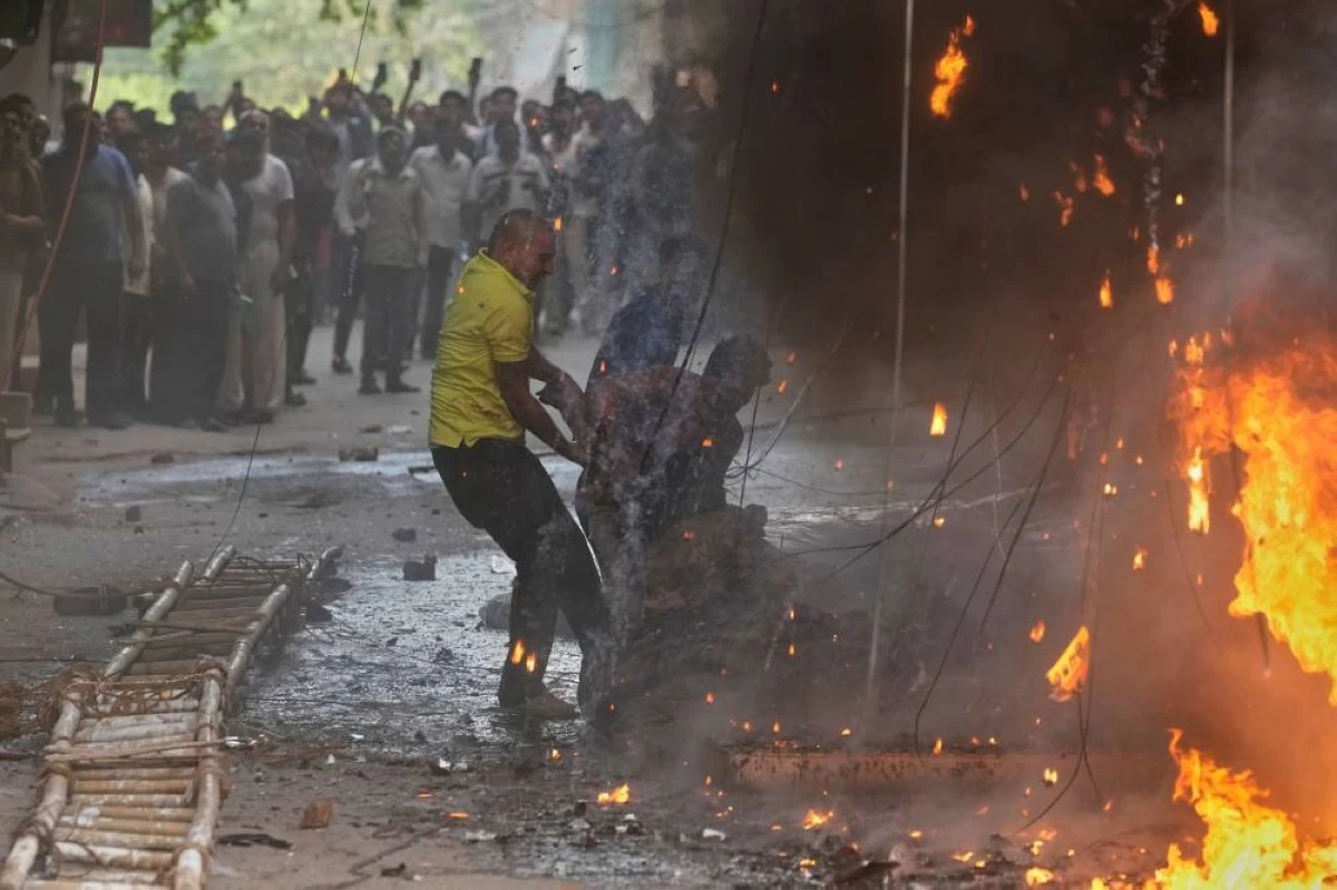 Local people rescue a foreign national from a hotel fire in New Delhi, India, Wednesday, June 3, 2026. (AP Photo/Manish Swarup)