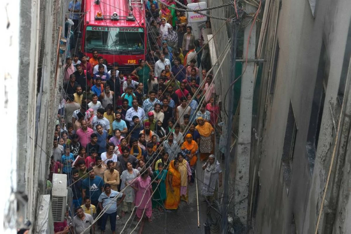 Locals and bystanders watch a hotel fire as firefighters work to douse the flames in New Delhi, India, Wednesday, June 3, 2026. (AP Photo/Manish Swarup)