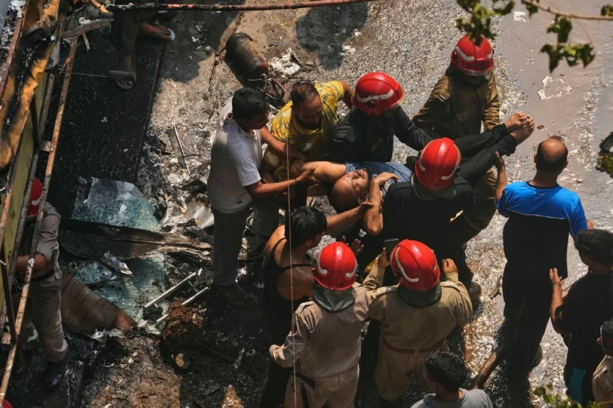 Firefighters rescue a foreign national from a hotel fire in New Delhi, India, Wednesday, June 3, 2026. (AP Photo/Manish Swarup)