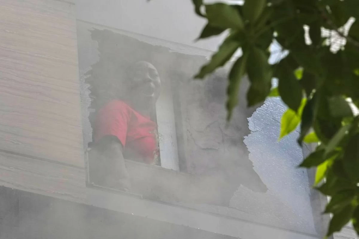 A foreign national woman shouts for help from a hotel window as fire engulfs the building in New Delhi, India, Wednesday, June 3, 2026. (AP Photo/Manish Swarup)