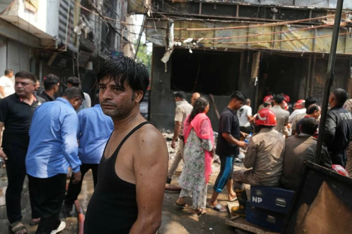 An exhausted local catches his breath after helping firefighters to douse a fire in a hotel in New Delhi, India, Wednesday, June 3, 2026. (AP Photo/Manish Swarup)