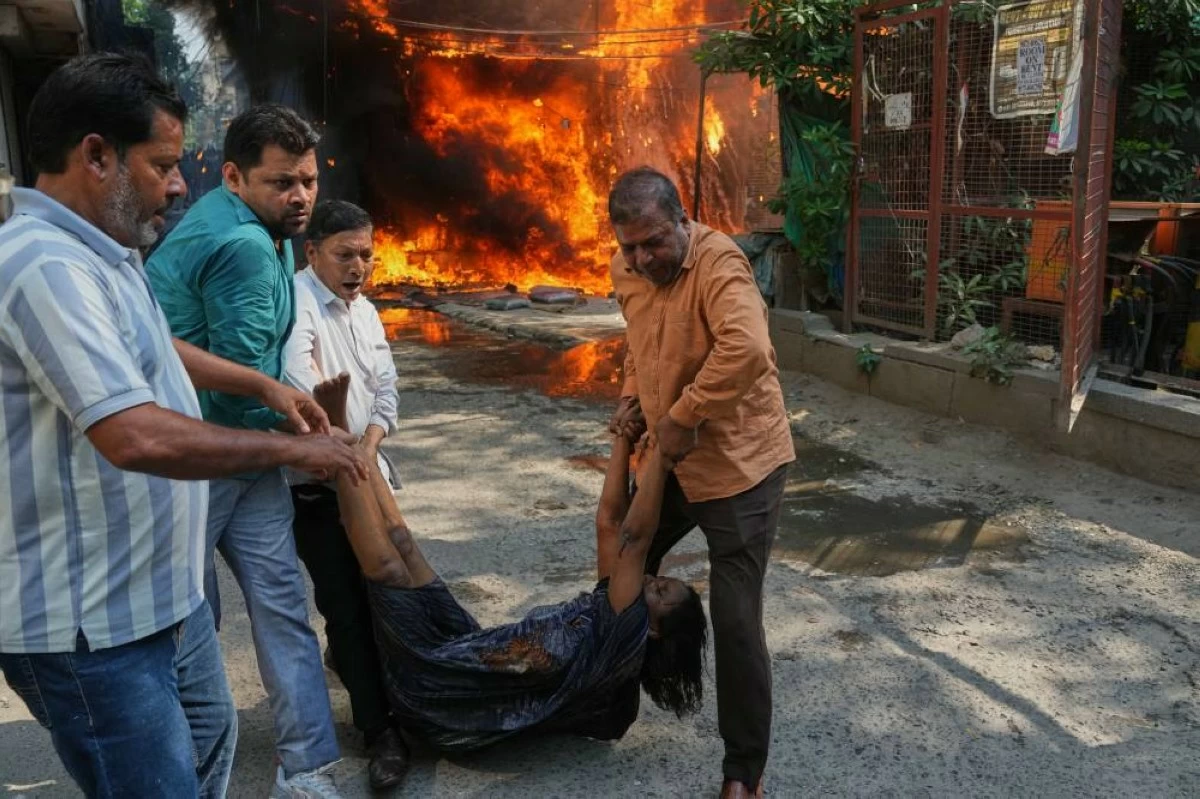 Local people rescue a foreign national from a hotel fire in New Delhi, India, Wednesday, June 3, 2026. (AP Photo/Manish Swarup)