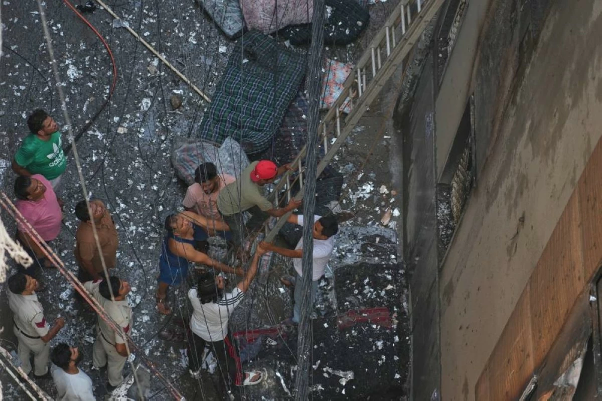 Firefighters and locals help in rescue effort of trapped people in a hotel fire in New Delhi, India, Wednesday, June 3, 2026. (AP Photo/Manish Swarup)