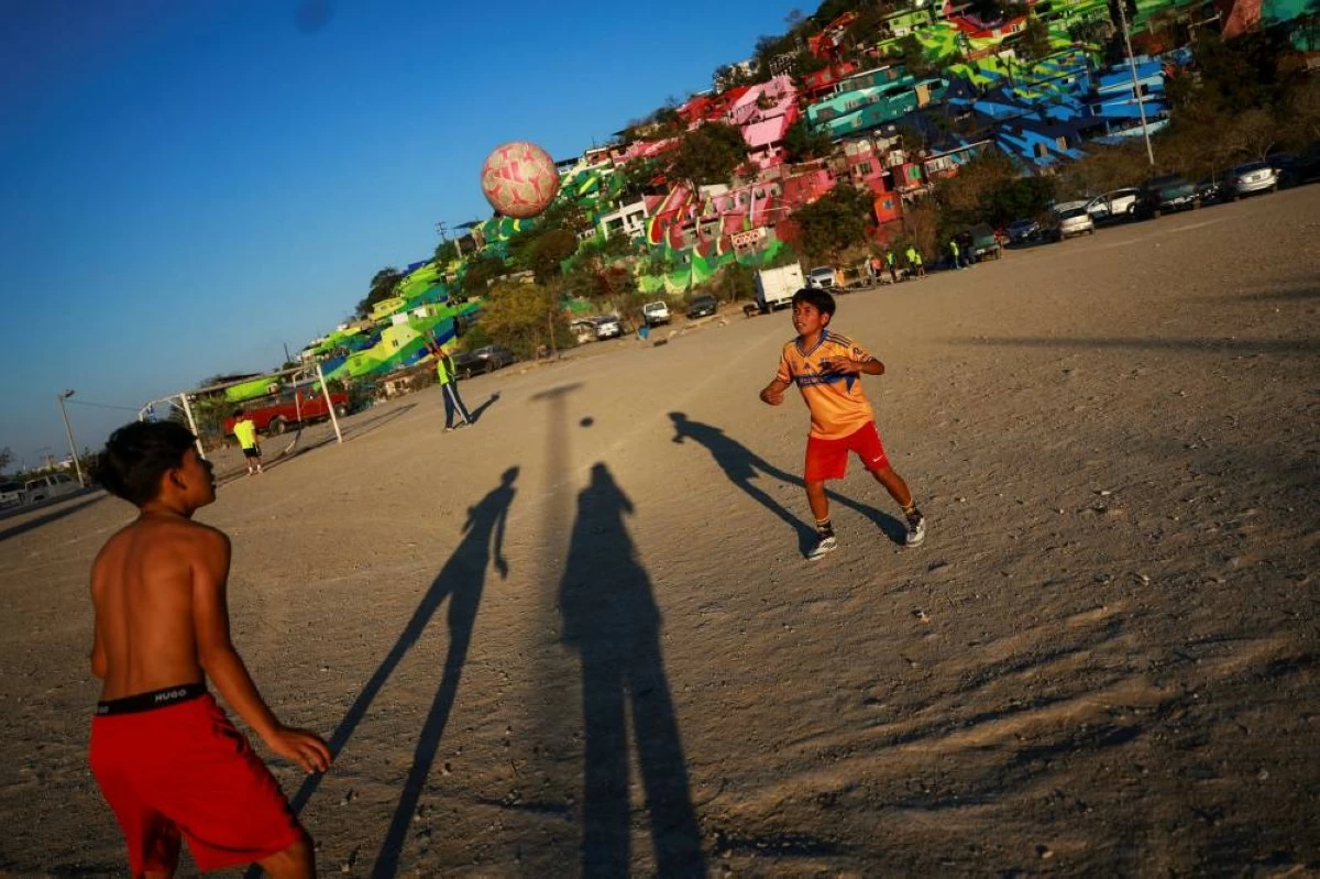 Humberto Guadalupe (left), 14, nicknamed "Messi", who dreams of being a professional soccer player, and Eduardo Reyes, 12, play during a soccer match that begins with listening to the word of God, followed by snacks organized by evangelists and brothers Rene Cardona and Andres Cardona, in Monterrey, Mexico, March 24, 2026. REUTERS/Raquel Cunha    