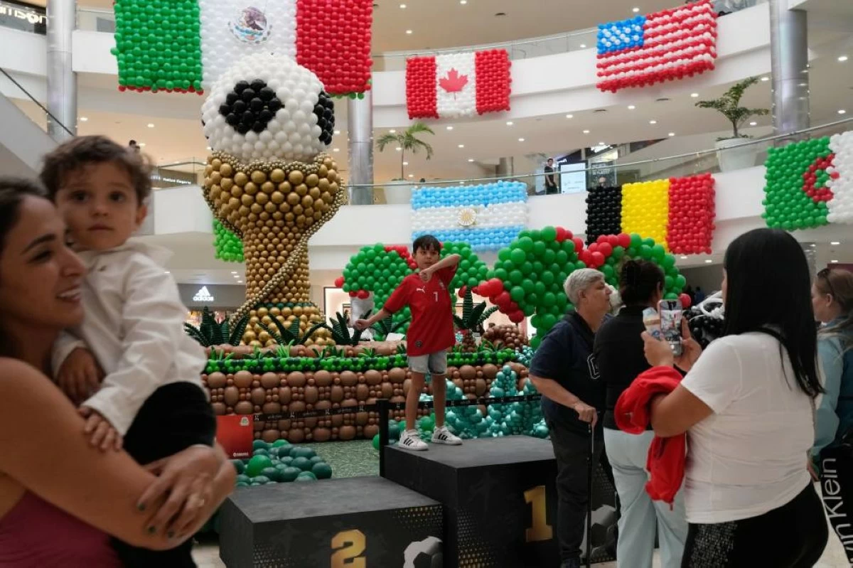 Shoppers stand in front of balloon flags of countries participating in the FIFA World Cup finals at a shopping centre in Guadalajara, Mexico. Picture credit: AP