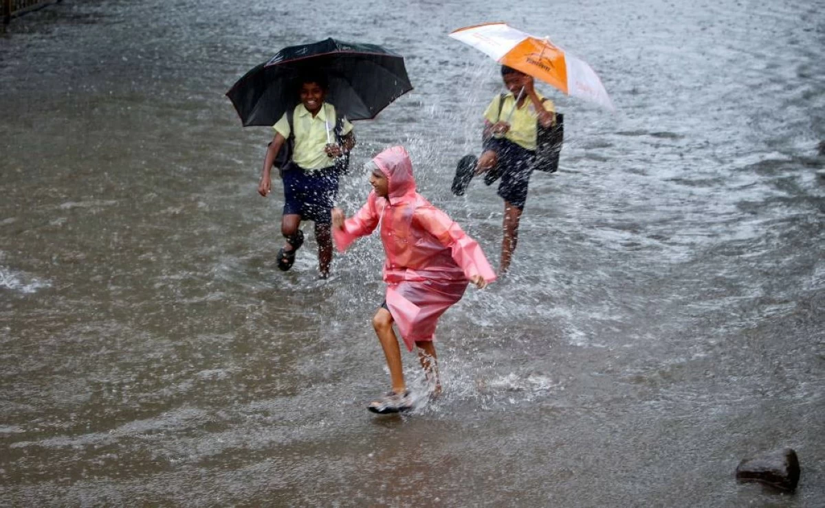 School children play on a flooded street during heavy monsoon rains in Mumbai in this file photo. REUTERS