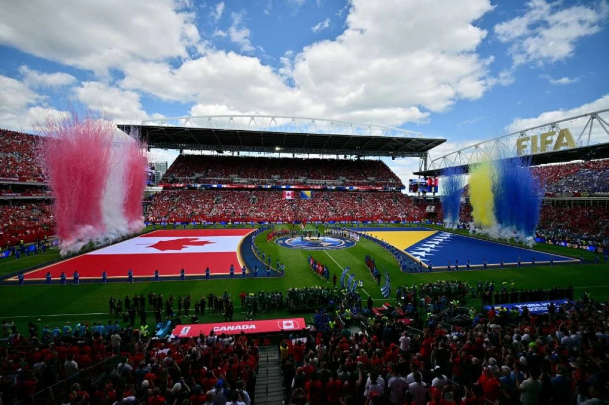 Pyrotechnics in national colors go off behind the flags on the pitch before the World Cup Group B match. Picture credit: AP