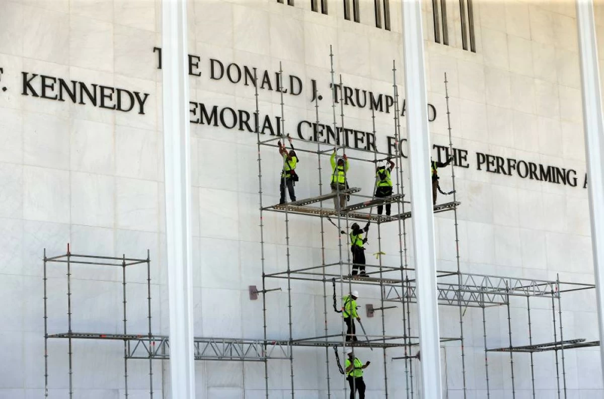 Workers construct scaffolding below the John F. Kennedy Center for the Performing Arts sign Friday, June 12, 2026, in Washington. (AP Photo/Rahmat Gul)