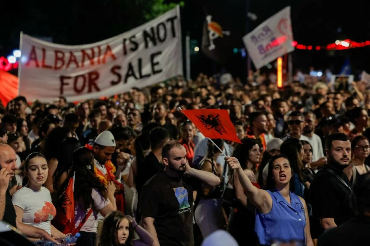 Protesters hold banners and Albanian national flags during a protest against a luxury resort, a plan by a company linked to Donald Trump's son-in-law, Jared Kushner, on an environmentally sensitive part of the Adriatic coast, in Tirana, Albania, June 12, 2026. REUTERS/Valdrin Xhemaj