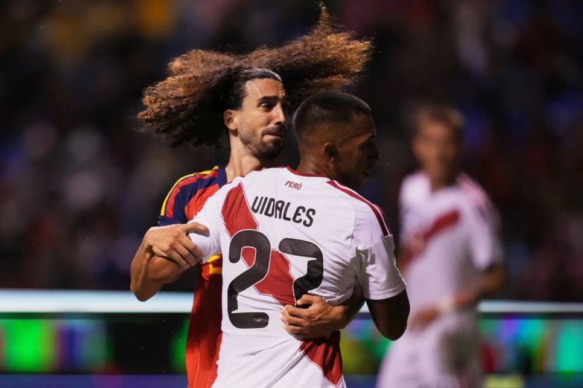 Spain's Marc Cucurella, facing camera, and Peru's Jhonny Vidales fight for the ball during an international soccer match in Puebla, Mexico, Monday, June 8, 2026. (AP)