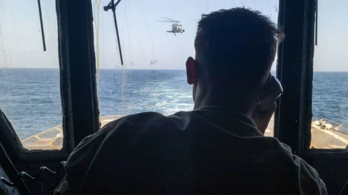 A US Sailor standing watch aboard guided-missile destroyer USS Michael Murphy observes flight operations in the Arabian Sea as US forces enforce the naval blockade on Iran.