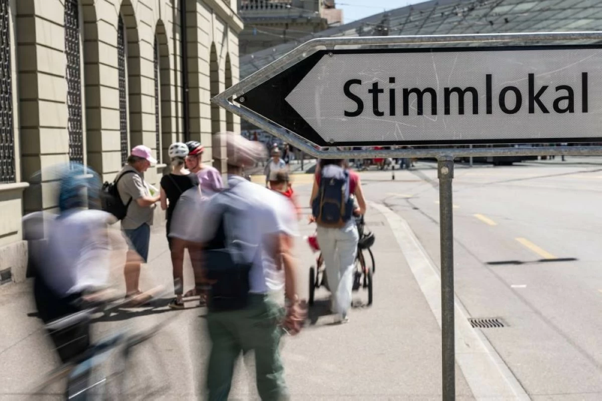 People approach the polling station near the train station on election Sunday, when voters are deciding on the "No to 10-Million Switzerland" and the Civil Protection Act, on Sunday, June 14, 2026, in Bern. AP