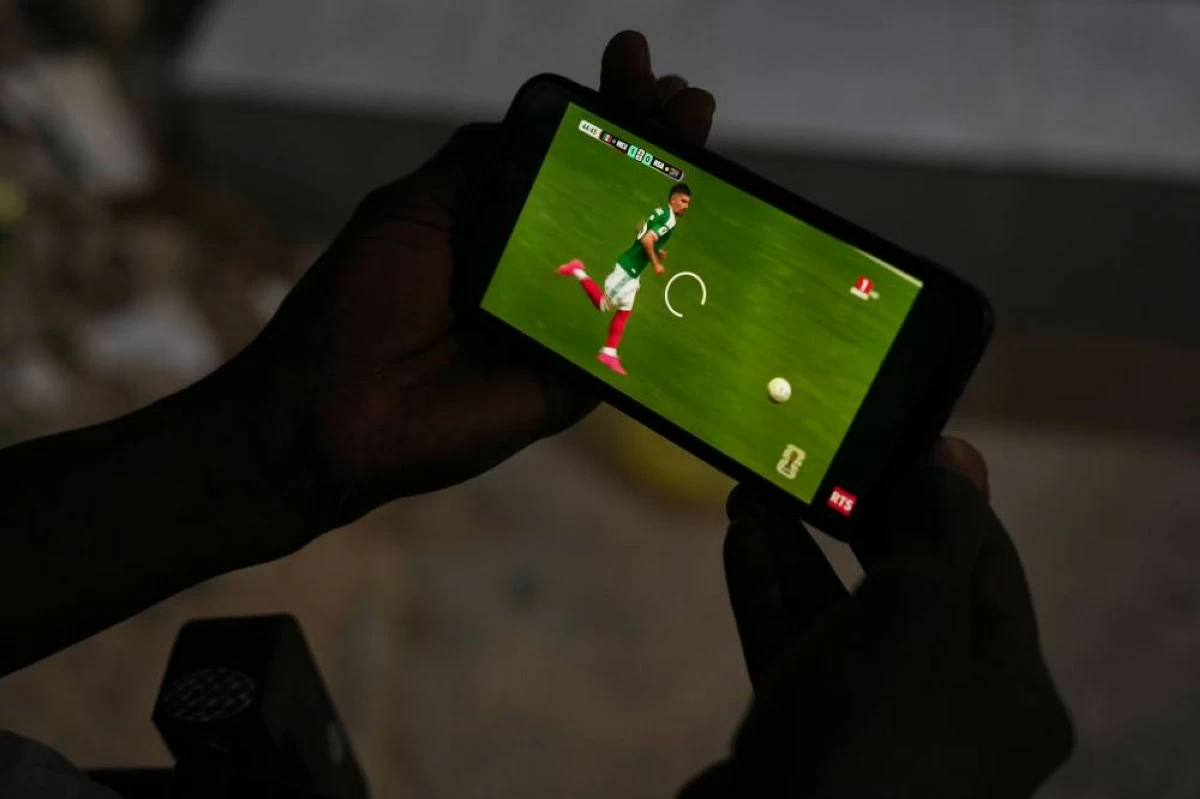 A soccer fan watches the opening match of the 2026 FIFA World Cup between Mexico and South Africa on his phone in Dakar, Senegal. Picture credit: AP