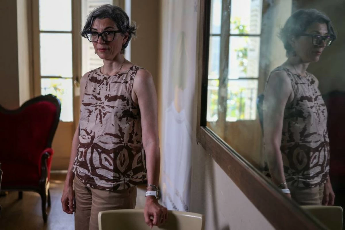 Irene Roggero Ugues, whose 12-year-old daughter took her own life in 2024, poses beside a mirror during an interview with Reuters at a cafe in Asti, Italy, May 28, 2026. REUTERS/Claudia Greco