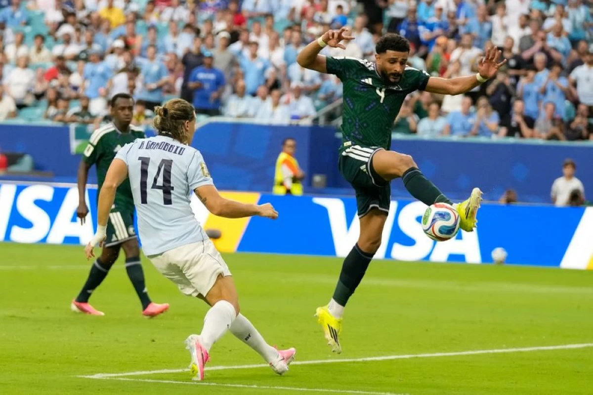 Saudi Arabia's Abdulelah Alamri plays the ball under the watch of Uruguay's Agustin Canobbio during a World Cup Group H soccer match in Miami Gardens, Fla. Picture credit: AP