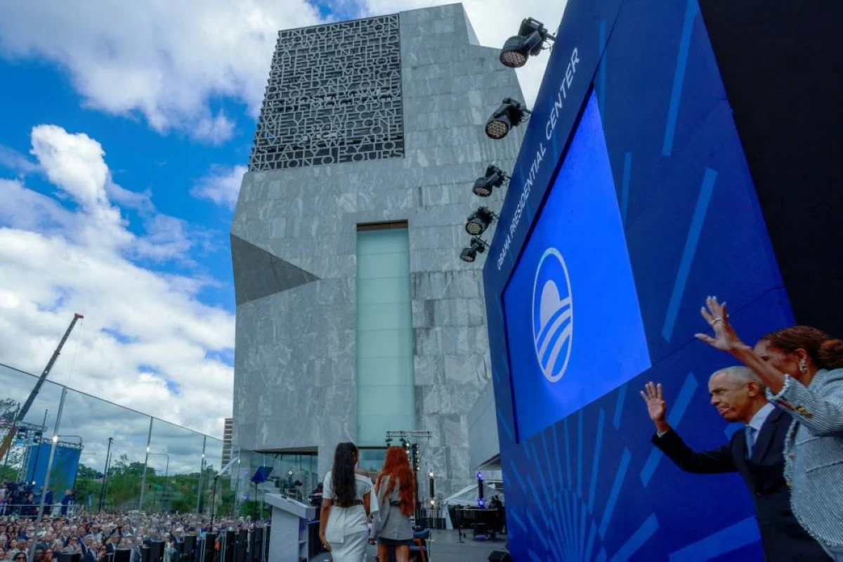 Former U.S. President Barack Obama and his wife, former first lady Michelle Obama wave as their daughters Malia Obama and Sasha Obama walk during the dedication ceremony for the opening of the Obama Presidential Center in Chicago, Illinois, U.S., June 18, 2026. Picture taken through the bulletproof glass. REUTERS