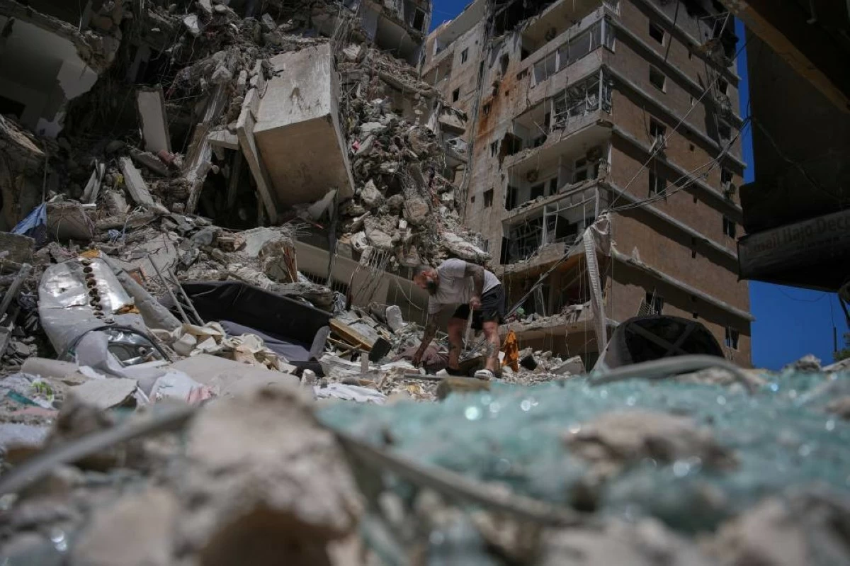 Barber Wissam Srour, 41, searches for belongings in the rubble of his barbershop, damaged in an Israeli strike, in the southern port city of Tyre, Lebanon, Friday, June 19, 2026. (AP)