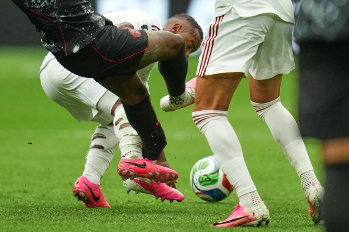 Canada's Ismael Kone, left, falls while being fouled against by Qatar's Assim Madibo during the World Cup Group B soccer match in Vancouver. Picture credit: AP