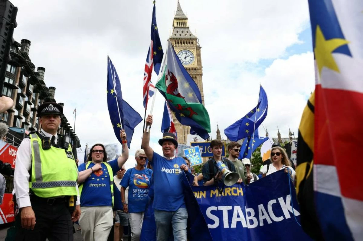 People walk past the Elizabeth Tower, commonly known as Big Ben, during the National Rejoin March IV organised by National Rejoin March (NRM), marking ten years since Britain voted to leave the European Union in 2016 and calling for closer cooperation between Britain and Europe, in London, Britain, June 20, 2026. REUTERS