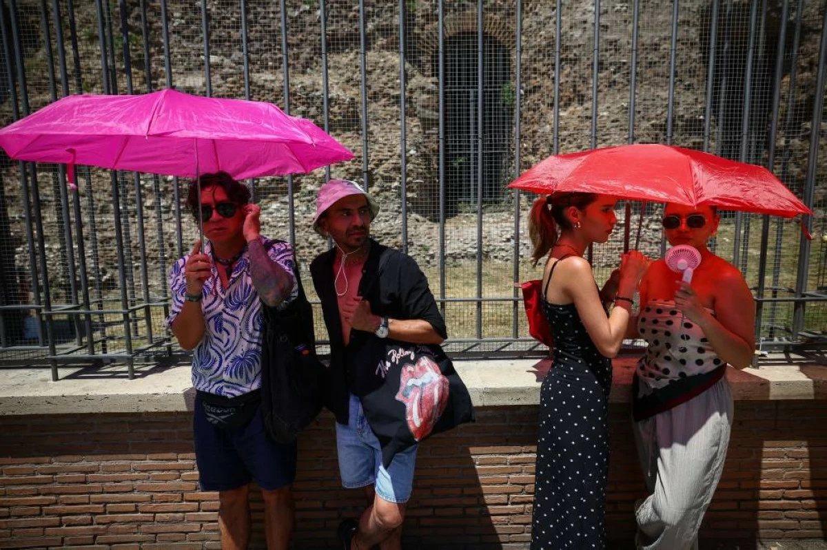 People shelter from the sun under umbrellas beside the base of the Temple of Venus and Roma, opposite the Colosseum, during a heatwave in Rome, Italy, June 20, 2026. REUTERS