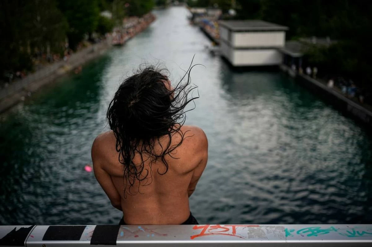 A man prepares to dive in the Limmat river during a heatwave in Zurich, Switzerland, Friday, June 19, 2026. AP