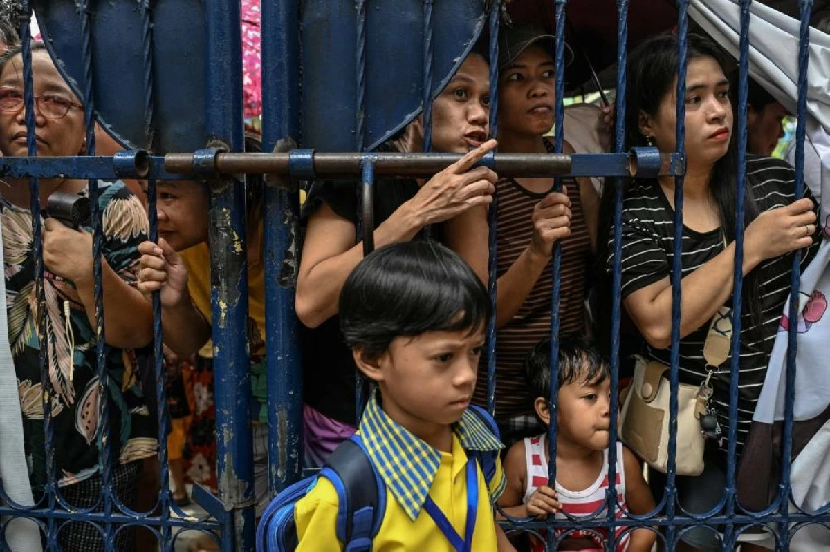 Students and parents wait for the start of the class at President Corazon Aquino Elementary School, a day after at least three students were killed and seven others injured in Deadly shooting in A school. (Reuters)