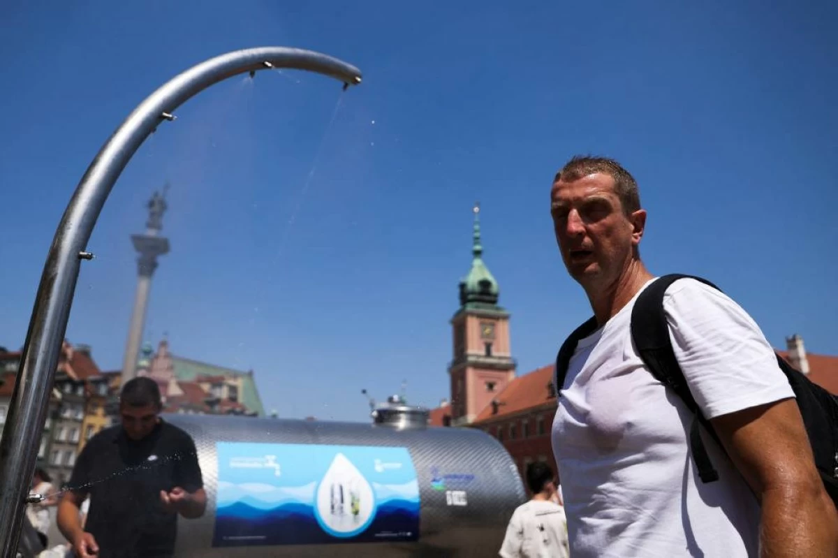 A man cools off under a water curtain as record temperatures hit Poland, in Warsaw, Poland, June 28, 2026. REUTERS