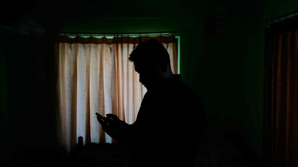  Safeer Mohammed Koorimannil looks at a photograph on his mobile phone of the injuries he said he sustained when his employer at the Tai Chang scam compound in Myanmar beat him for underperformance in Sulthan Bathery in the southern state of Kerala, India, Thursday, March 12, 2026. (AP)