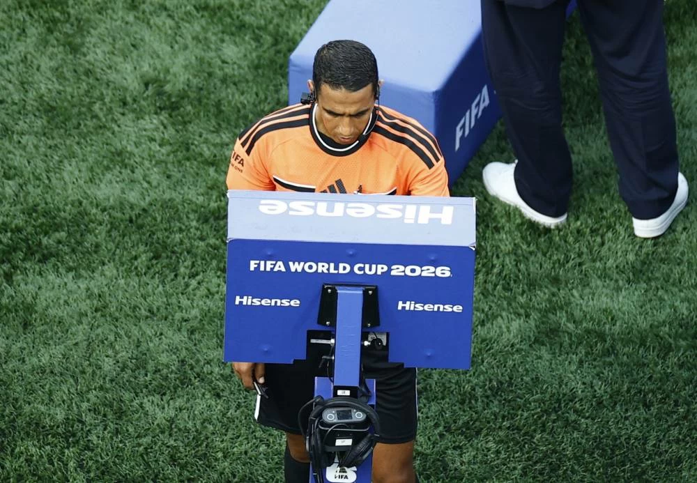 Referee Jalal Jayed looks at the VAR monitor before a goal for Germany is disallowed, in the Germany v Paraguay match. Picture credit: Reuters