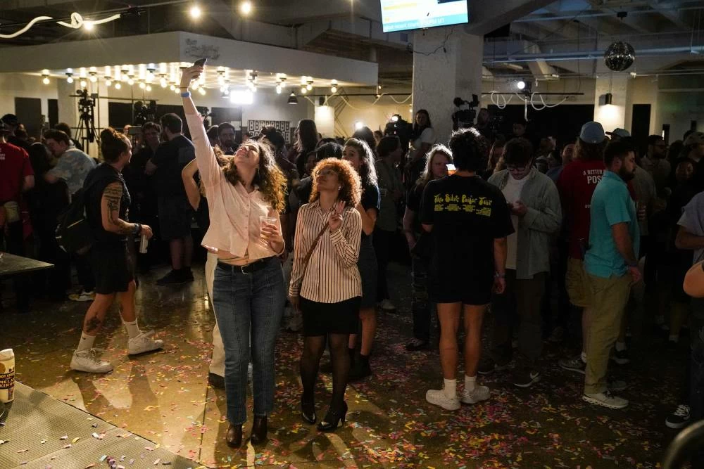 Taylor Vaughan and Sarah Johnson take a selfie at Democratic congressional candidate Melat Kiros' primary election night watch party, at The Broadway, Tuesday, June 30, 2026, in Denver. (AP Photo/Rebecca Slezak)