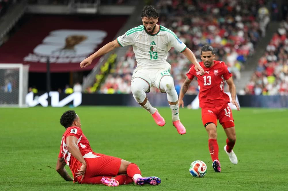 Switzerland's Noah Okafor (19) falls as Algeria's Jaouen Hadjam (13) jumps over him to take control of the ball during the World Cup round of 32 soccer match between Switzerland and Algeria in Vancouver, British Columbia, Thursday, July 2, 2026. (AP)
