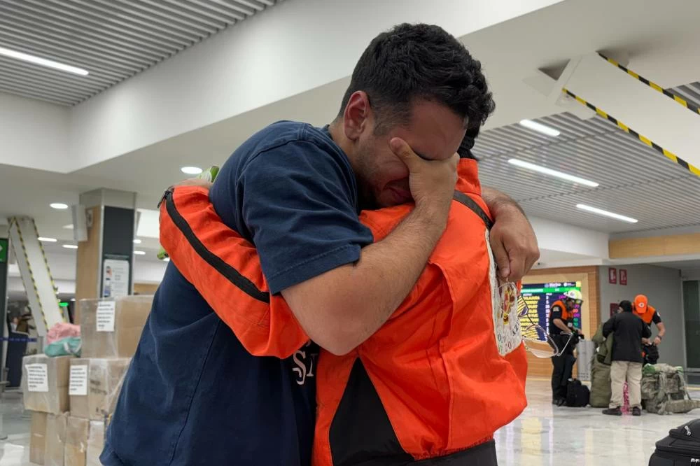 German Bello, right, a volunteer with the Mexican search-and-rescue brigade Los Topos Azteca, embraces a Venezuelan man who approached the team to thank them as they departed for Venezuela from Mexico City's airport, Tuesday, June 30, 2026. (AP)