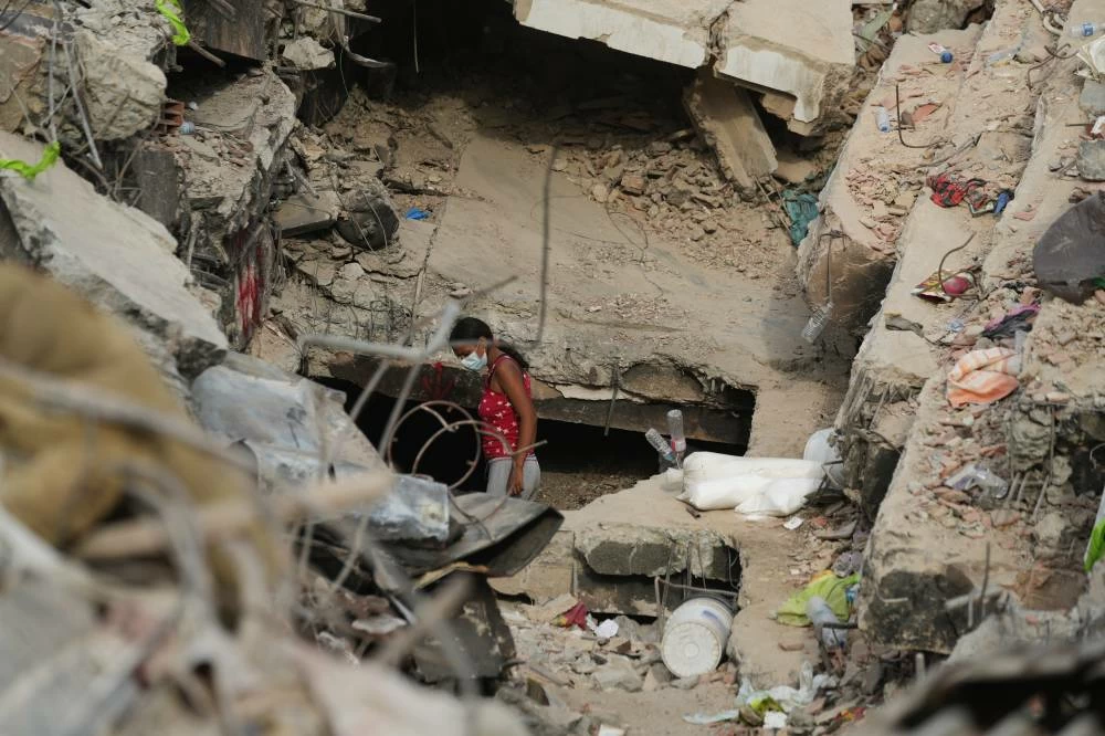A woman searches through the rubble of a building damaged in the earthquakes that struck La Guaira, Venezuela, Thursday, July 2, 2026. (AP)