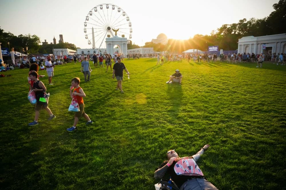 A person lays on the National Mall at sunset during the Great American State Fair, in an extreme heat wave, Friday, July 3, 2026, in Washington. (AP)