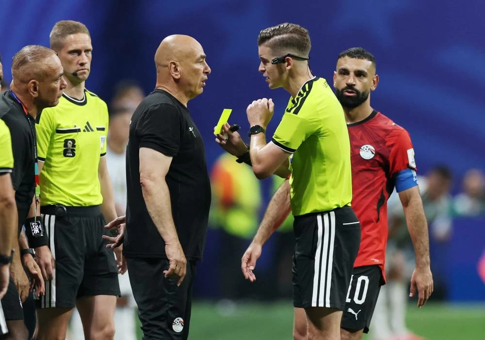 Egypt coach Hossam Hassan is shown a yellow card by referee Francois Letexier. Picture credit: Reuters