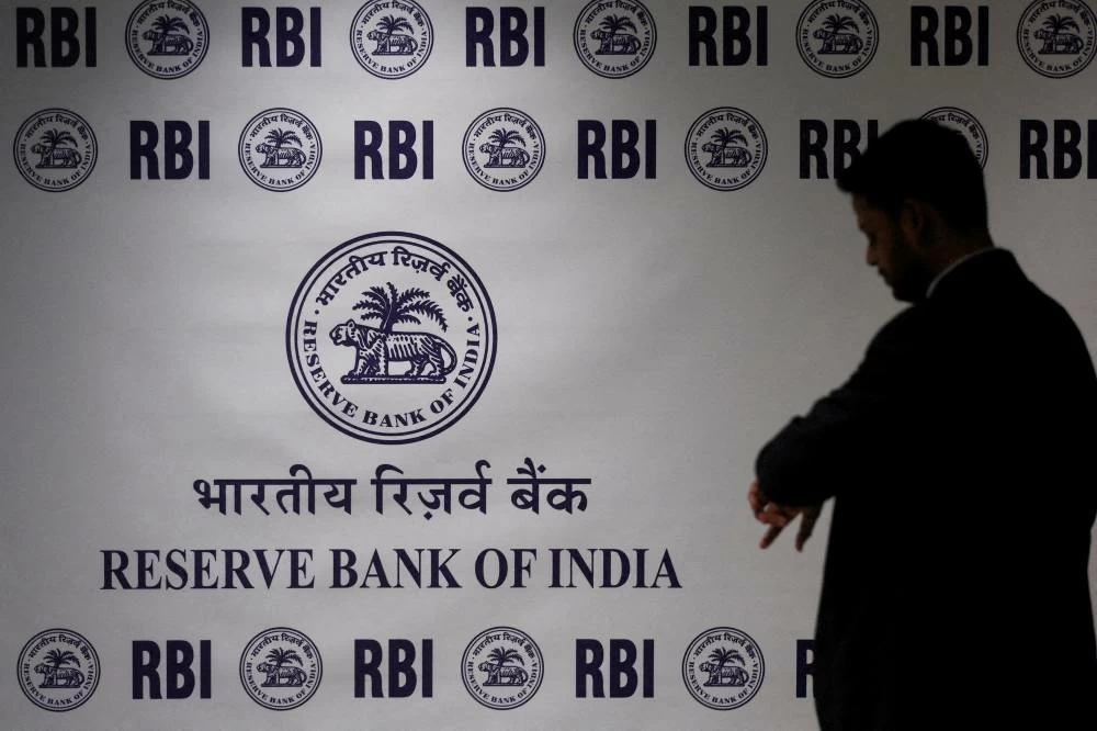 man stands in front of the Reserve Bank of India (RBI) logo inside its headquarters in Mumbai, India. (Reuters)