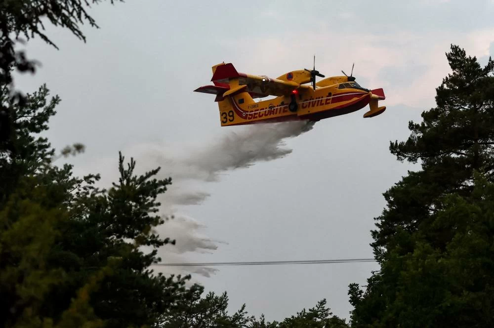 A Canadair firefighting aircraft works to contain wildfires at the Fontainebleau forest, in Acheres-la-Foret, as a heatwave affects large parts of France, July 13, 2026. Reuters