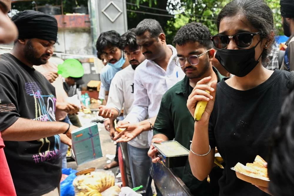 Volunteers distribute food received from supporters to protestors during a demonstration demanding educational reforms as part of the Cockroach Janta Party's ongoing protest movement in New Delhi, India, Thursday, July 23, 2026. (AP)