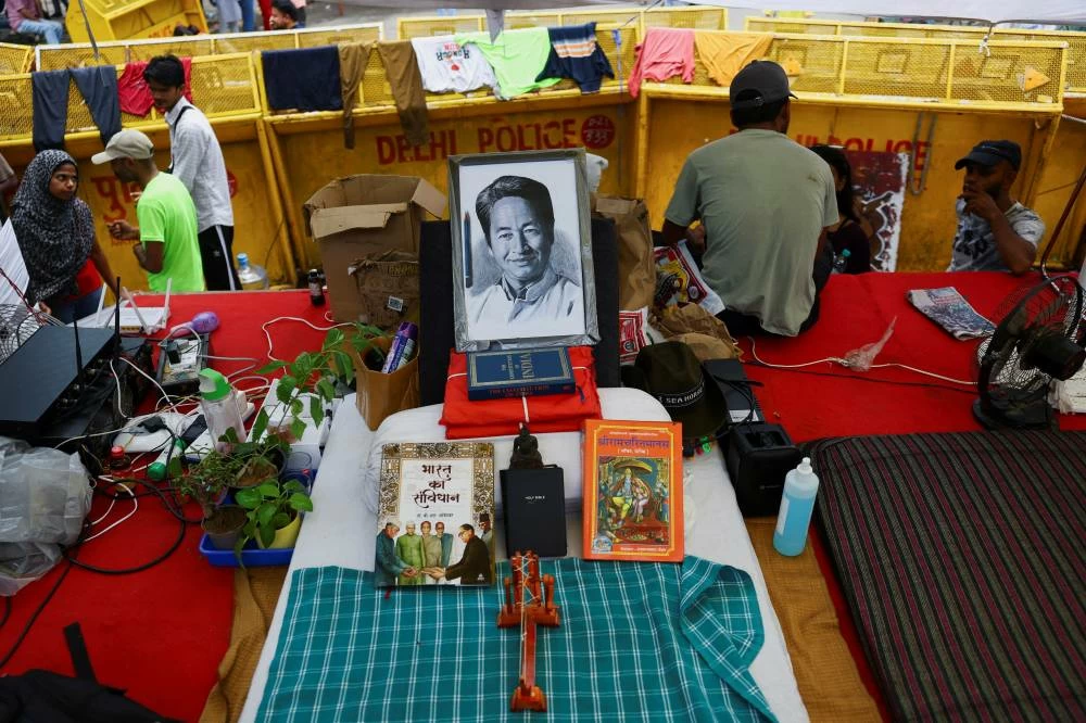 Books lie beside a portrait of Sonam Wangchuk on the bed that he had been using before police took him away from the protest site. (Reuters)